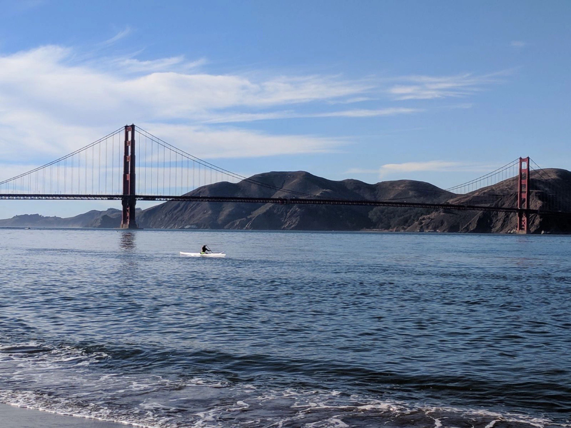 Paddleboarder crossing beneath the Golden Gate Bridge