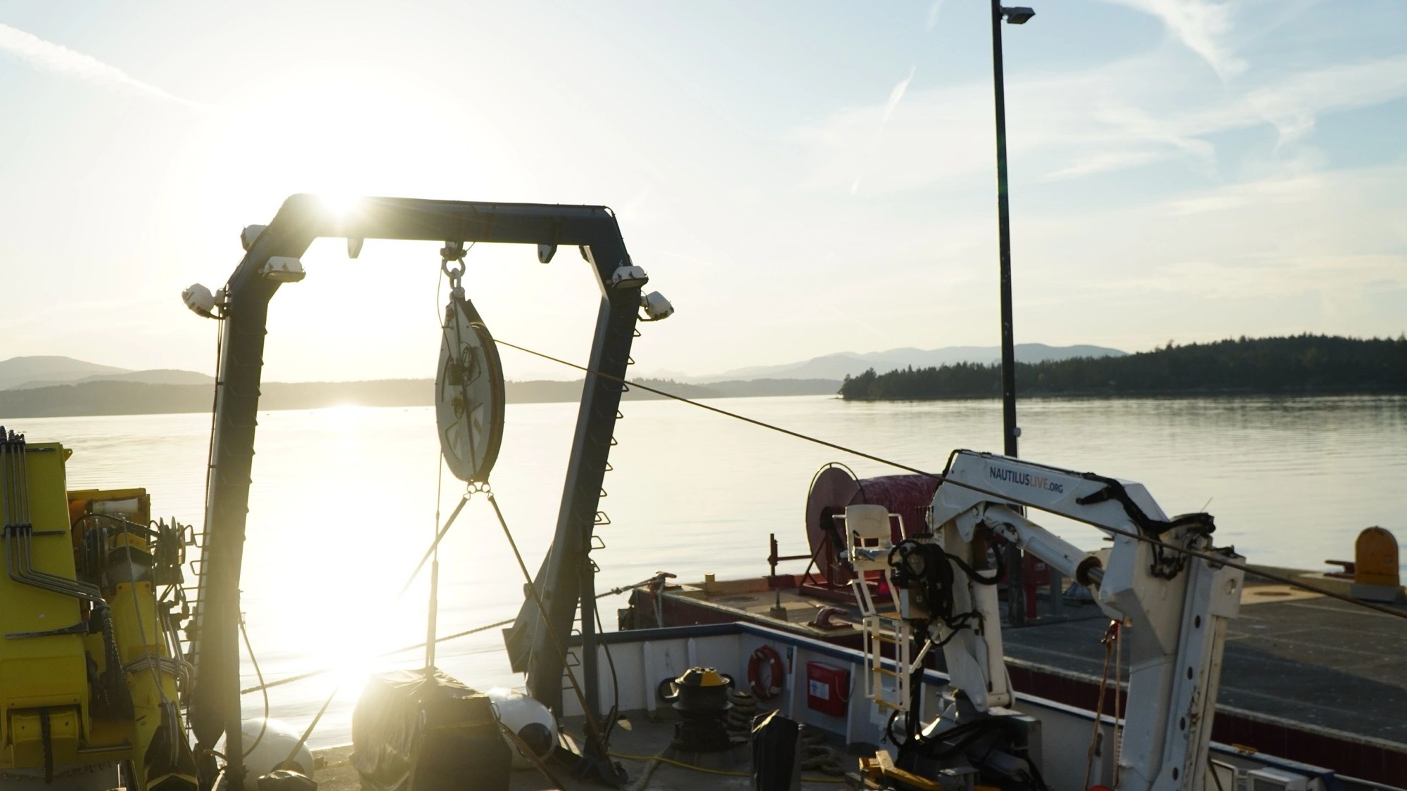 Research vessel deck rigging silhouetted at dawn