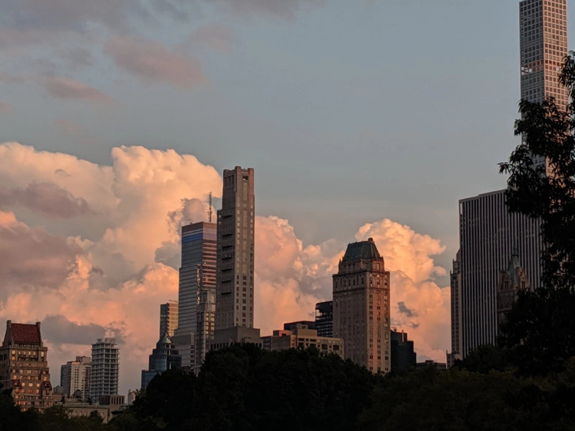 Thunderheads building over a city skyline at golden hour